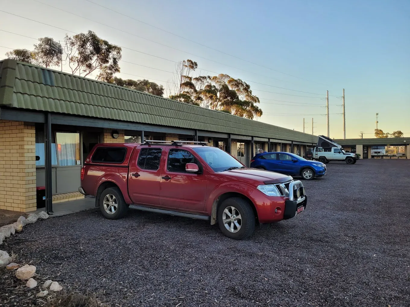 Motel parking with vehicles outside rooms